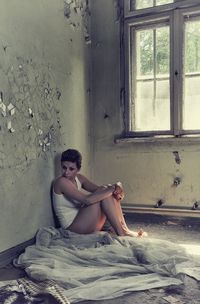 Young woman sitting on bed