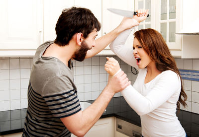 Happy woman standing against wall at home