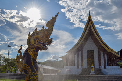 Statue of temple against building and sky