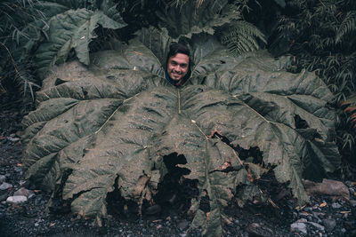 Portrait of smiling young man against plants