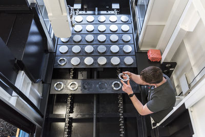 Man examining workpiece in factory