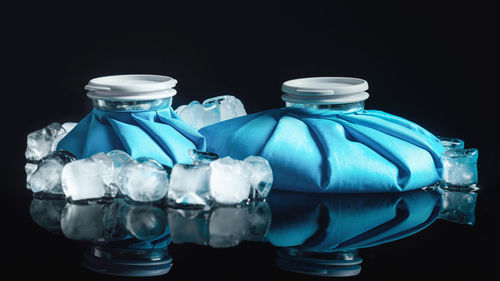 Cold therapy. reusable blue ice bags for cold therapy, isolated on black reflective background