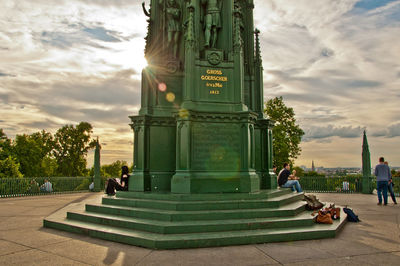 Silhouette of people standing against cloudy sky