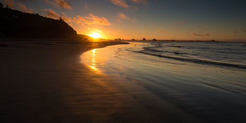 Scenic view of beach against sky during sunset