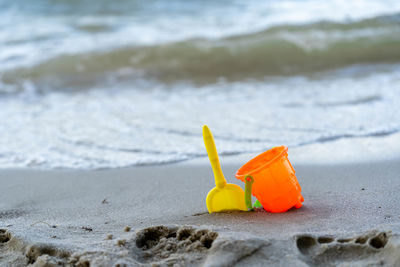 Close-up of yellow toy on beach