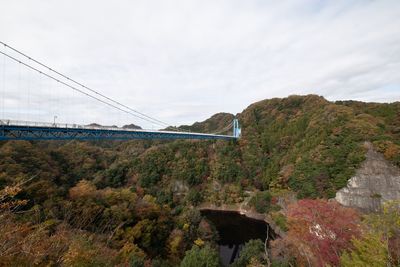 Bridge over mountain against sky