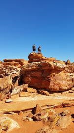 Low angle view of rock formation against clear blue sky
