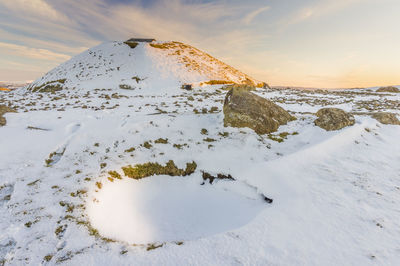 Scenic view of snowcapped mountain against sky during sunset