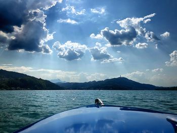 Boat in sea against cloudy sky