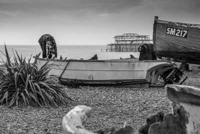 Boat moored on beach against sky