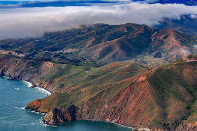 Scenic view of sea and mountains against sky