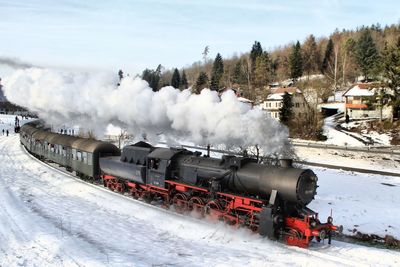 Train on railroad tracks against sky during winter