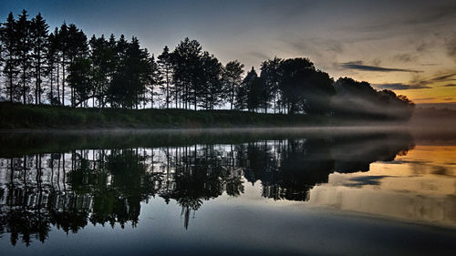Reflection of trees in lake against sky