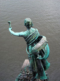 Statue against lake