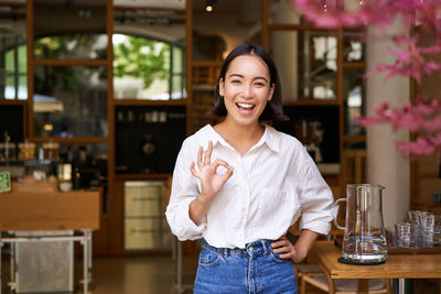 Portrait of young woman standing in cafe