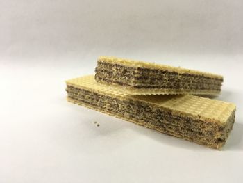 Close-up of bread on table against white background