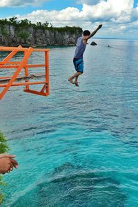 Full length of woman jumping in water