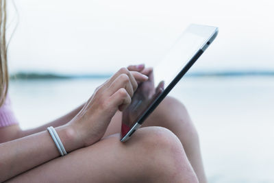 Close-up of girl using digital tablet at water