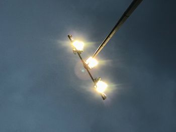 Low angle view of illuminated sun against sky