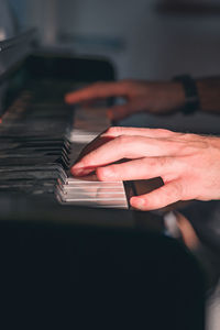 Cropped hands of man playing piano