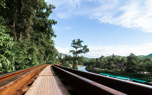 Railroad tracks by trees against sky