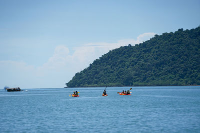 People on sea against sky