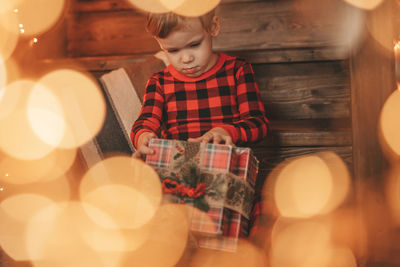 Rear view of girl standing on illuminated christmas tree