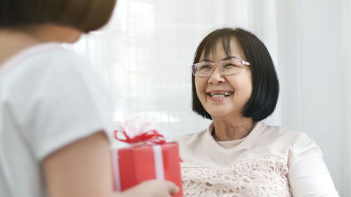 Girl giving girl to grandmother