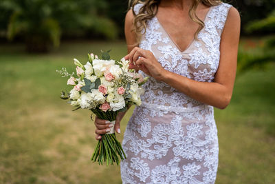 Midsection of woman holding white flowering plant