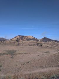 Scenic view of desert against clear blue sky