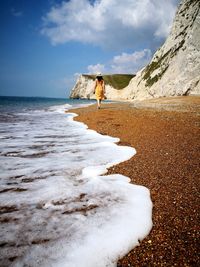 Rear view of man standing on beach