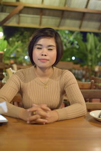 Portrait of woman sitting on table in restaurant