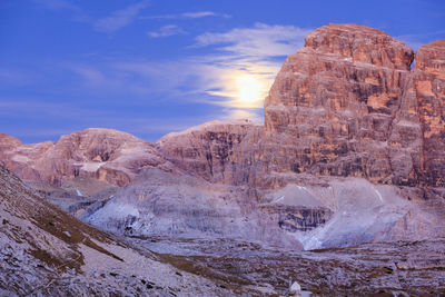 Moonrise over the dolomites mountains in alpenglow