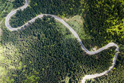 Winding road from high mountain pass, in summer time. aerial view by drone . romania