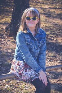 Smiling girl sitting on railing at playground