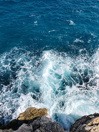 High angle view of waves splashing on rocks