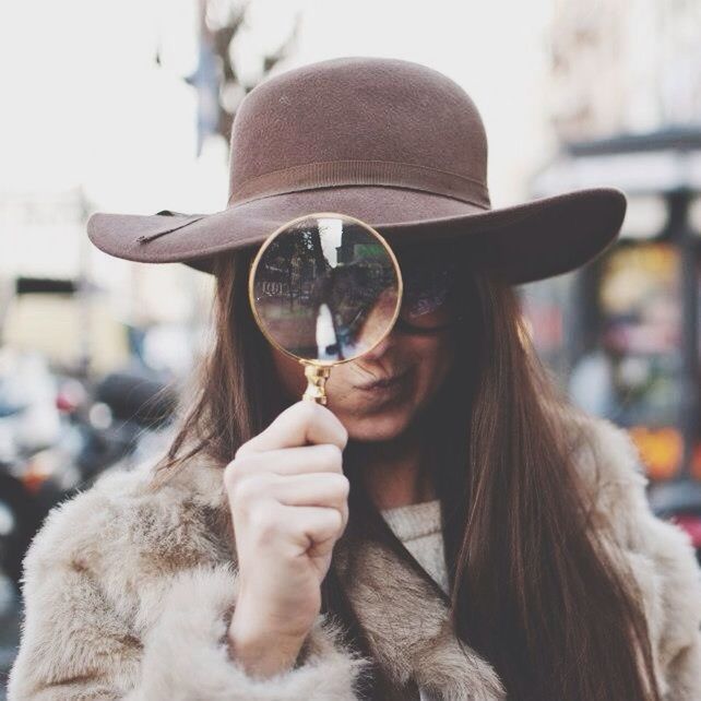 focus on foreground, headshot, lifestyles, leisure activity, holding, close-up, sitting, waist up, young adult, incidental people, head and shoulders, person, hat, front view, young women, portrait, day