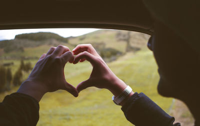 Hands making heart shape in car