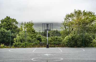 View of basketball hoop on road against sky
