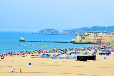 Group of people on beach against sky
