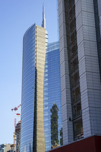 Low angle view of modern buildings against blue sky