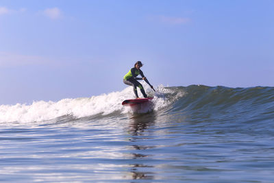 Female sup surfer on a wave