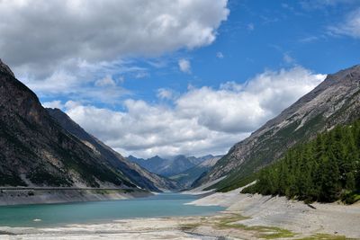 Scenic view of lake by mountains against sky