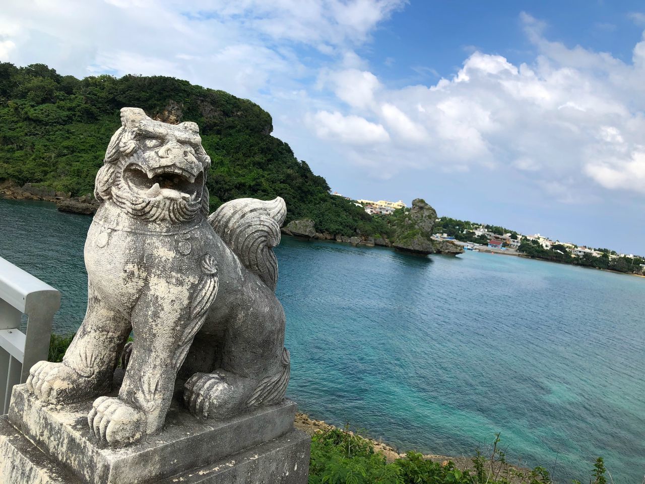 STATUE BY LAKE AGAINST SKY