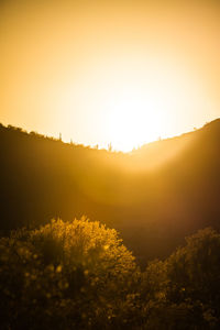 Scenic view of landscape against orange sky