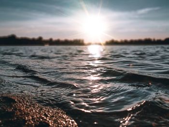 Surface level of sea against sunset sky