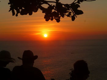 Silhouette couple on beach against sky during sunset