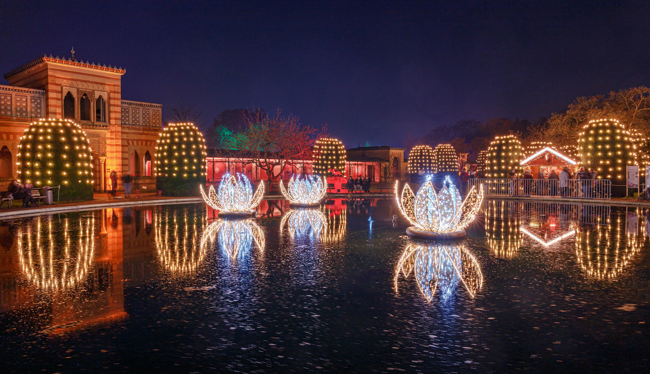 illuminated, architecture, built structure, night, building exterior, water, reflection, city, waterfront, nature, sky, river, no people, building, lighting equipment, connection, motion, travel destinations, glowing, outdoors, light, arch bridge