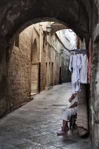 Woman hanging on wall of old building