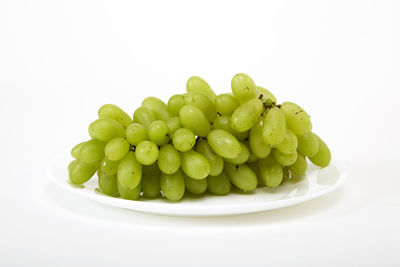Close-up of fruits in plate against white background